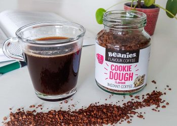 Beanies flavour coffee met kopje koffie ernaast en koffie ervoor op tafel